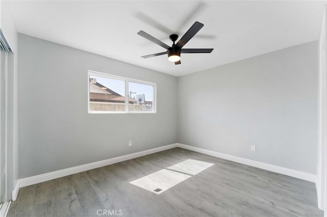 unfurnished bedroom with ceiling fan, a closet, baseboards, and wood finished floors