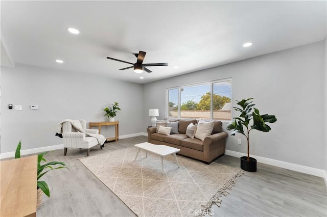 living area with light wood-style flooring, baseboards, a ceiling fan, and recessed lighting