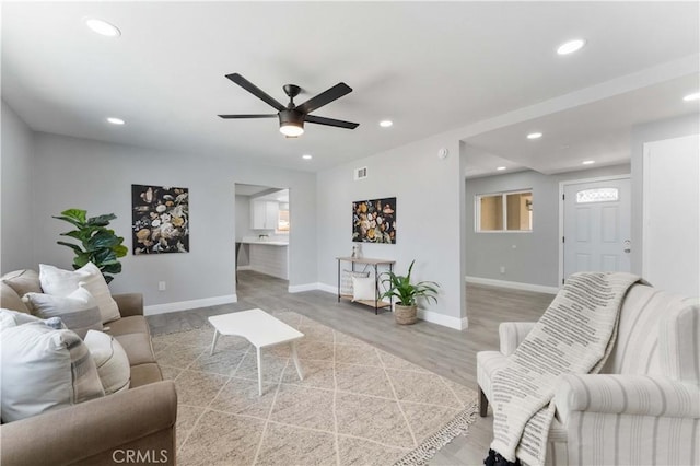 living room with recessed lighting, baseboards, and wood finished floors