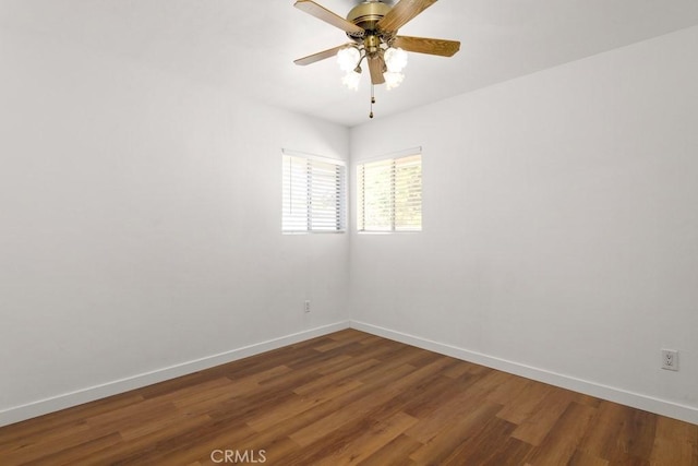 empty room with ceiling fan, baseboards, and wood finished floors