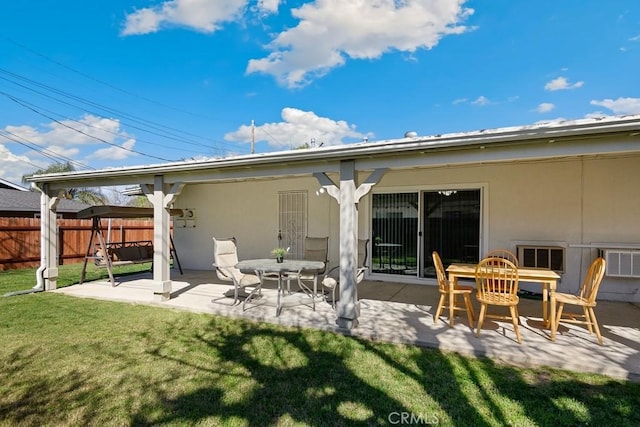 back of property with stucco siding, fence, a lawn, and a patio