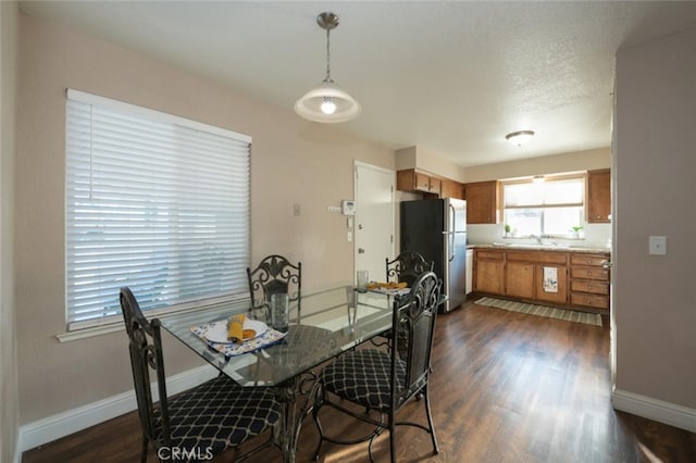 dining area with baseboards and dark wood-type flooring