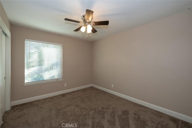 unfurnished room with carpet, a ceiling fan, and baseboards