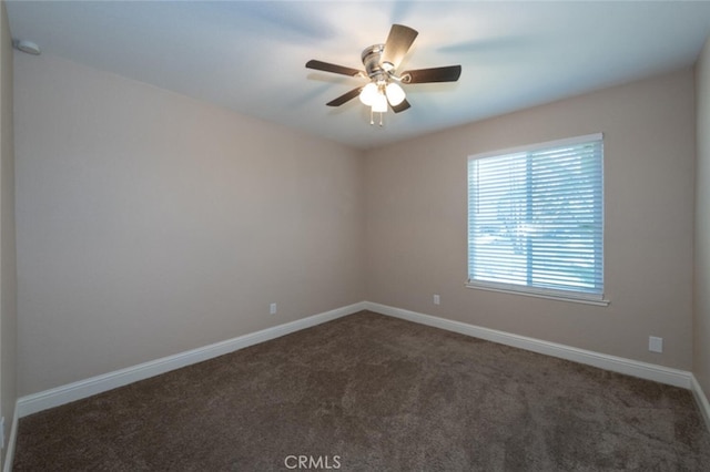 carpeted spare room with baseboards and a ceiling fan