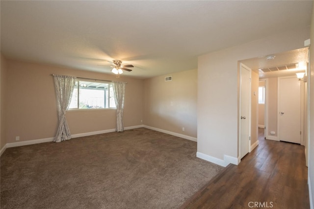 empty room featuring baseboards, visible vents, and ceiling fan