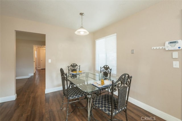 dining area featuring baseboards and wood finished floors