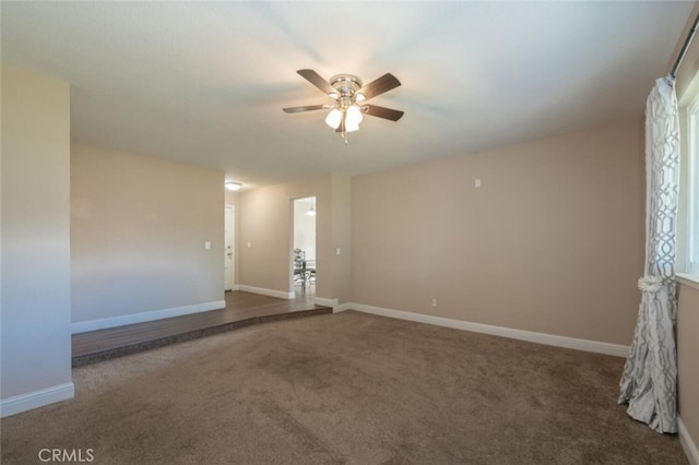 unfurnished room with carpet floors, baseboards, and a ceiling fan