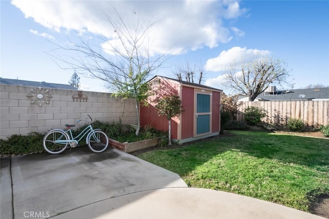 view of yard featuring an outbuilding, a fenced backyard, and a shed