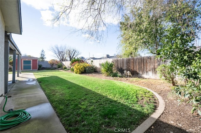 view of yard with a fenced backyard, a shed, and an outdoor structure