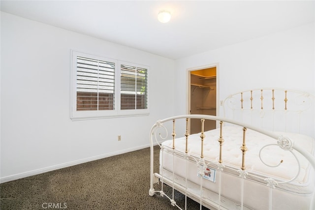 bedroom with baseboards and a walk in closet