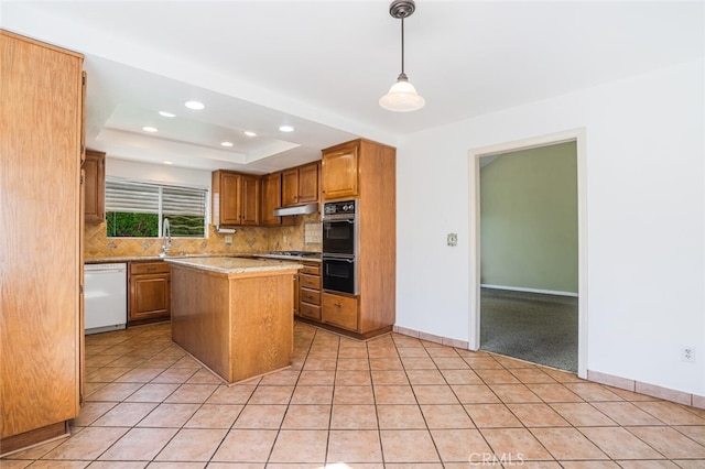 kitchen with light tile patterned flooring, light countertops, dishwasher, a tray ceiling, and tasteful backsplash