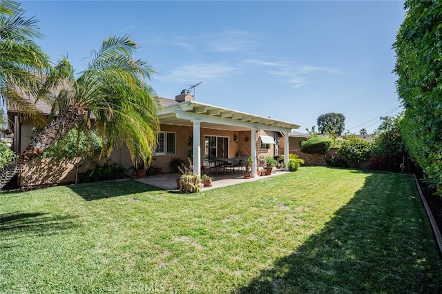 rear view of house featuring a patio, a fenced backyard, a yard, stucco siding, and a chimney