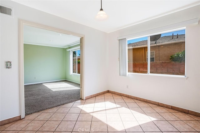 empty room with light carpet, baseboards, visible vents, and light tile patterned flooring