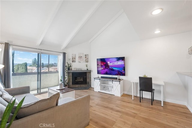 living area featuring vaulted ceiling with beams, light wood-type flooring, a fireplace, and baseboards