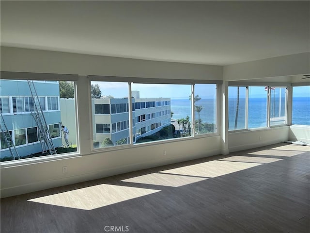 unfurnished sunroom featuring a water view and plenty of natural light