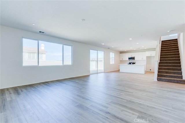 12990 Campbell Ct, Hesperia, CA 92344 - unfurnished living room featuring light wood-style floors, stairs, visible vents, and recessed lighting