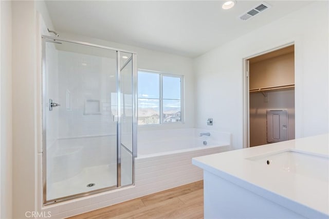12990 Campbell Ct, Hesperia, CA 92344 - full bath with a garden tub, wood finished floors, a shower stall, and visible vents