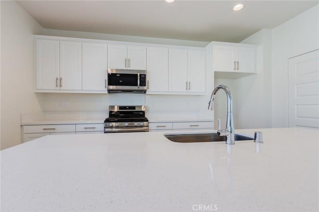 12990 Campbell Ct, Hesperia, CA 92344 - kitchen featuring white cabinetry, appliances with stainless steel finishes, light countertops, and a sink