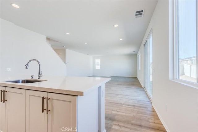 12990 Campbell Ct, Hesperia, CA 92344 - kitchen with visible vents, light wood-style flooring, light countertops, a sink, and recessed lighting
