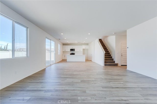 12990 Campbell Ct, Hesperia, CA 92344 - unfurnished living room with light wood-type flooring, stairs, and recessed lighting