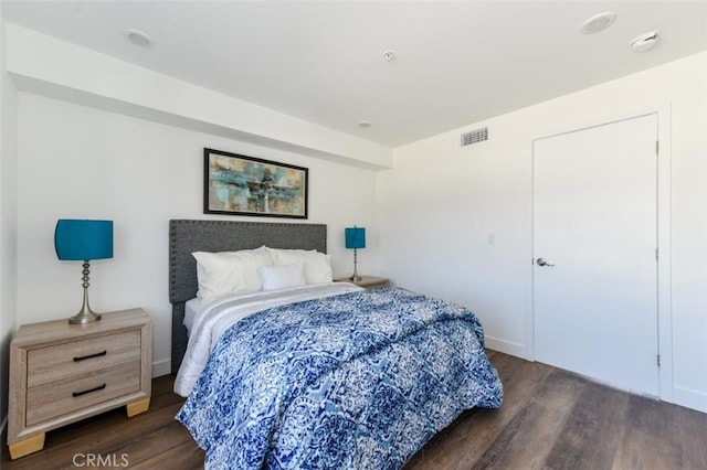 bedroom featuring wood finished floors, visible vents, and baseboards