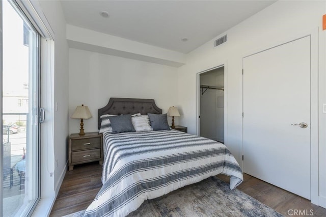 bedroom featuring a closet, multiple windows, dark wood finished floors, and visible vents