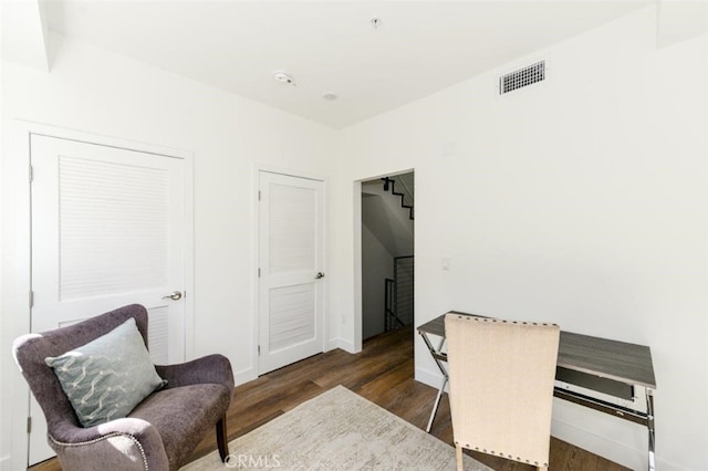 living area with wood finished floors and visible vents