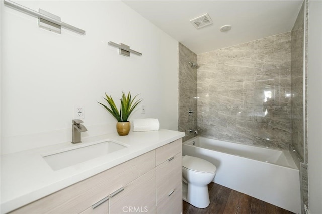 full bathroom featuring visible vents, toilet, wood finished floors, bathtub / shower combination, and vanity