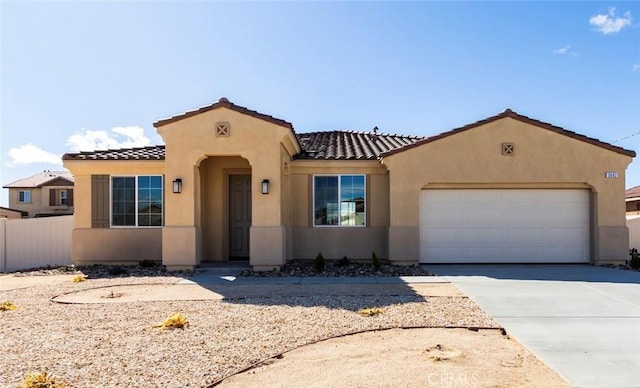 mediterranean / spanish-style house with concrete driveway, fence, and stucco siding