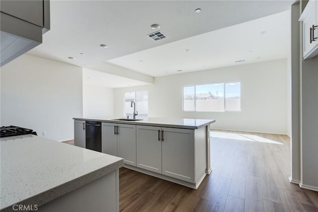 kitchen with open floor plan, dark wood-type flooring, a sink, and visible vents