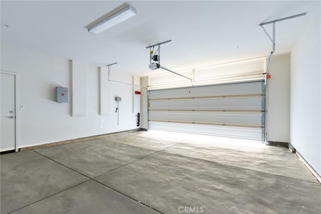 garage with a garage door opener, electric panel, and baseboards