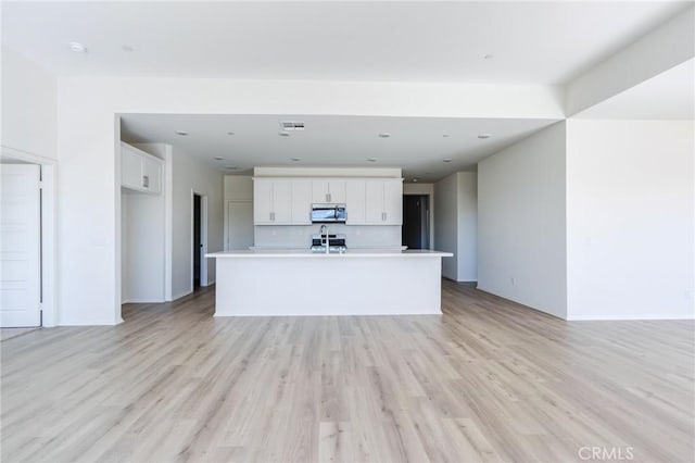 unfurnished living room featuring light wood-style flooring and baseboards