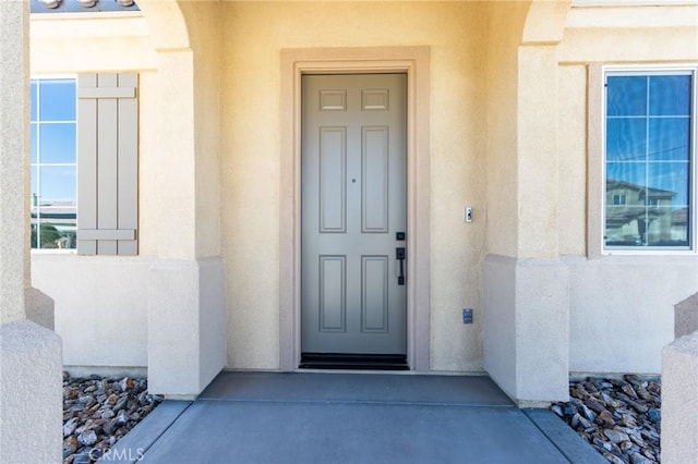 property entrance featuring stucco siding