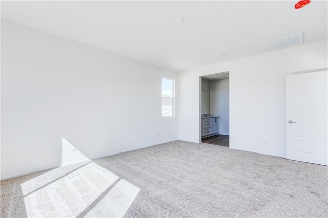 unfurnished bedroom with dark colored carpet and visible vents