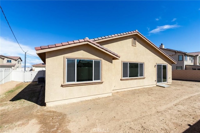 rear view of house with a fenced backyard and stucco siding