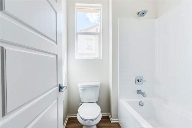 full bath featuring baseboards, bathing tub / shower combination, toilet, and wood finished floors