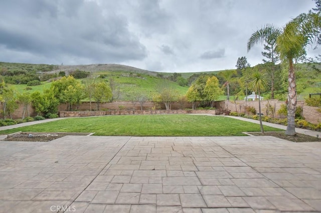 view of patio with fence and a mountain view