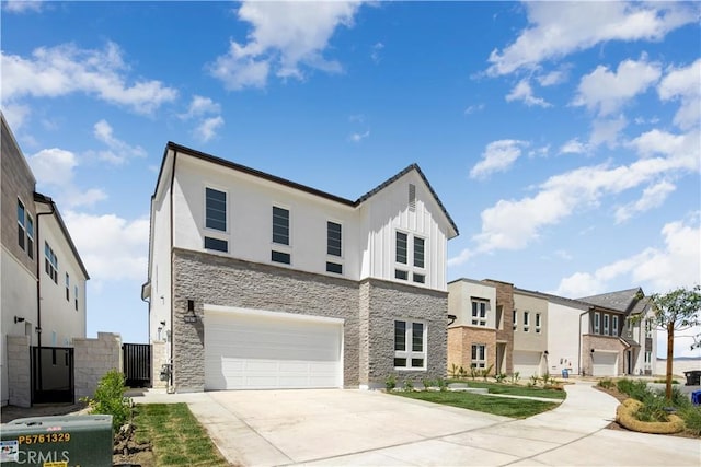 view of front of house featuring board and batten siding, stone siding, driveway, and an attached garage