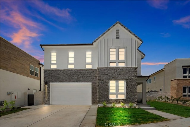 view of front facade featuring concrete driveway, an attached garage, board and batten siding, stone siding, and a front lawn