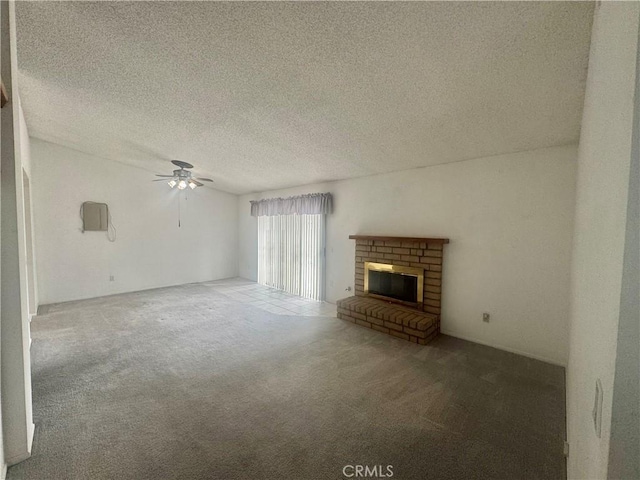 unfurnished living room with carpet, a brick fireplace, a ceiling fan, and a textured ceiling