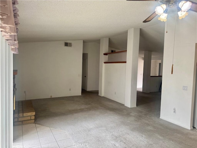 spare room featuring visible vents, a ceiling fan, a textured ceiling, lofted ceiling, and light colored carpet