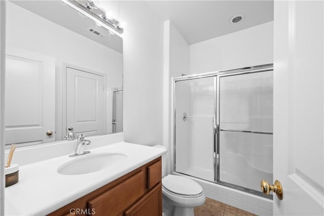 bathroom with visible vents, vanity, toilet, and an enclosed shower