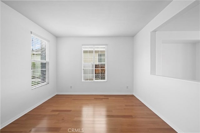 spare room with wood finished floors and baseboards