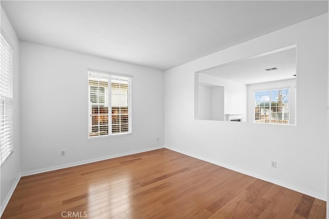 spare room with baseboards and wood finished floors