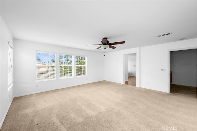 unfurnished bedroom featuring ceiling fan, visible vents, and light colored carpet