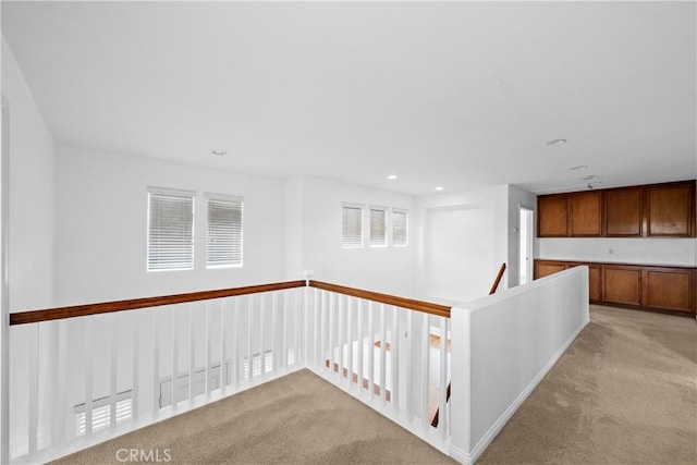 hall featuring light carpet and recessed lighting