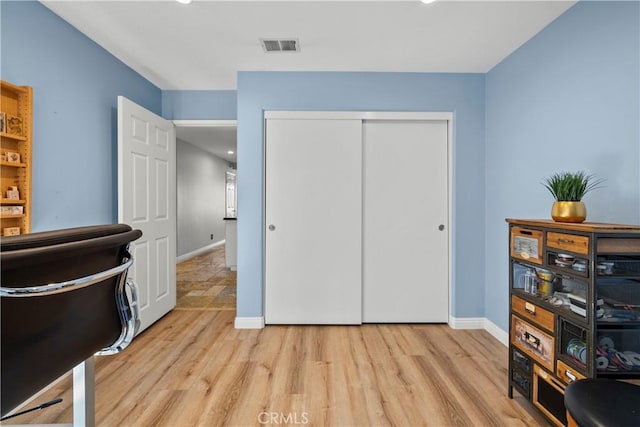 office space with light wood-type flooring, baseboards, and visible vents