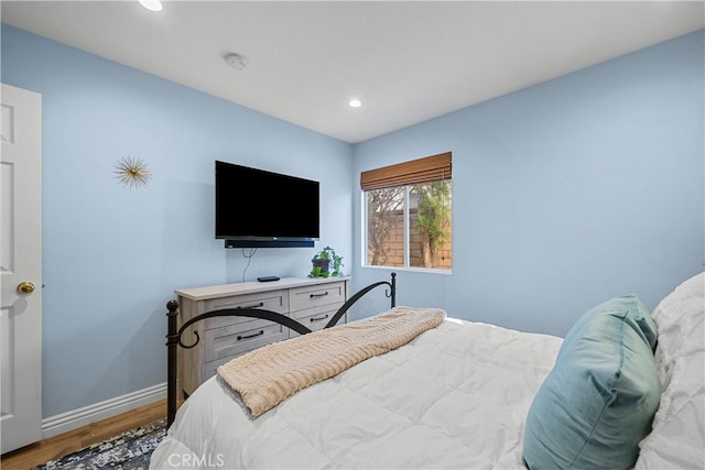 bedroom featuring baseboards, wood finished floors, and recessed lighting