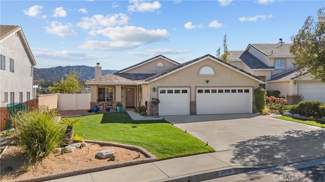 view of front of house featuring an attached garage, fence, driveway, stucco siding, and a front yard