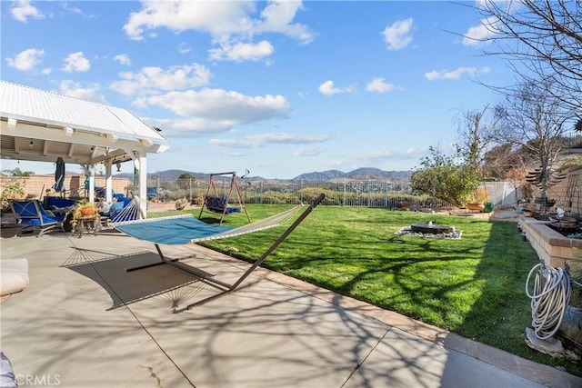 view of patio / terrace with a mountain view, a fire pit, and fence